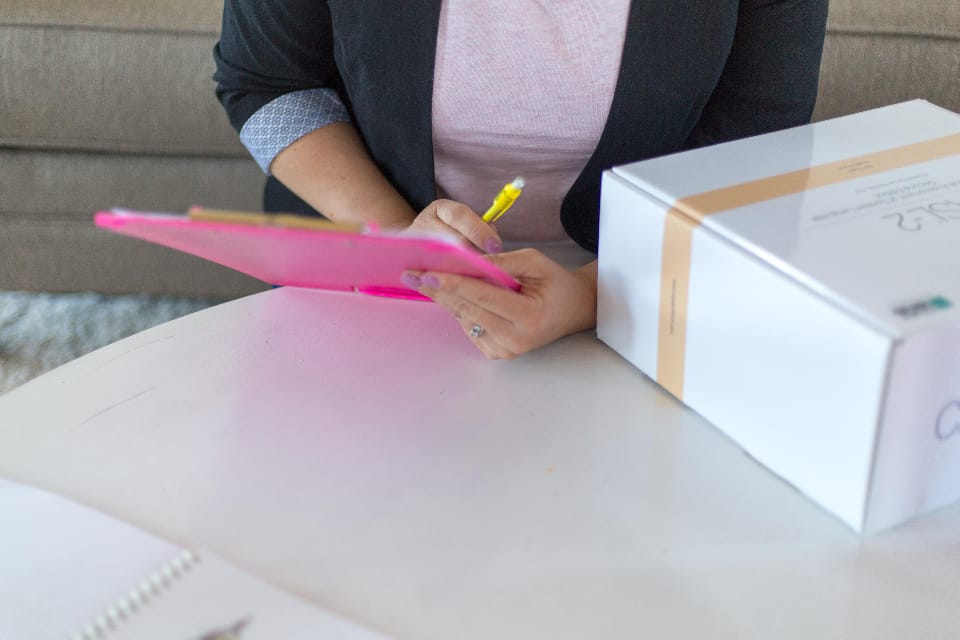 A hand holding a clipboard with a checklist