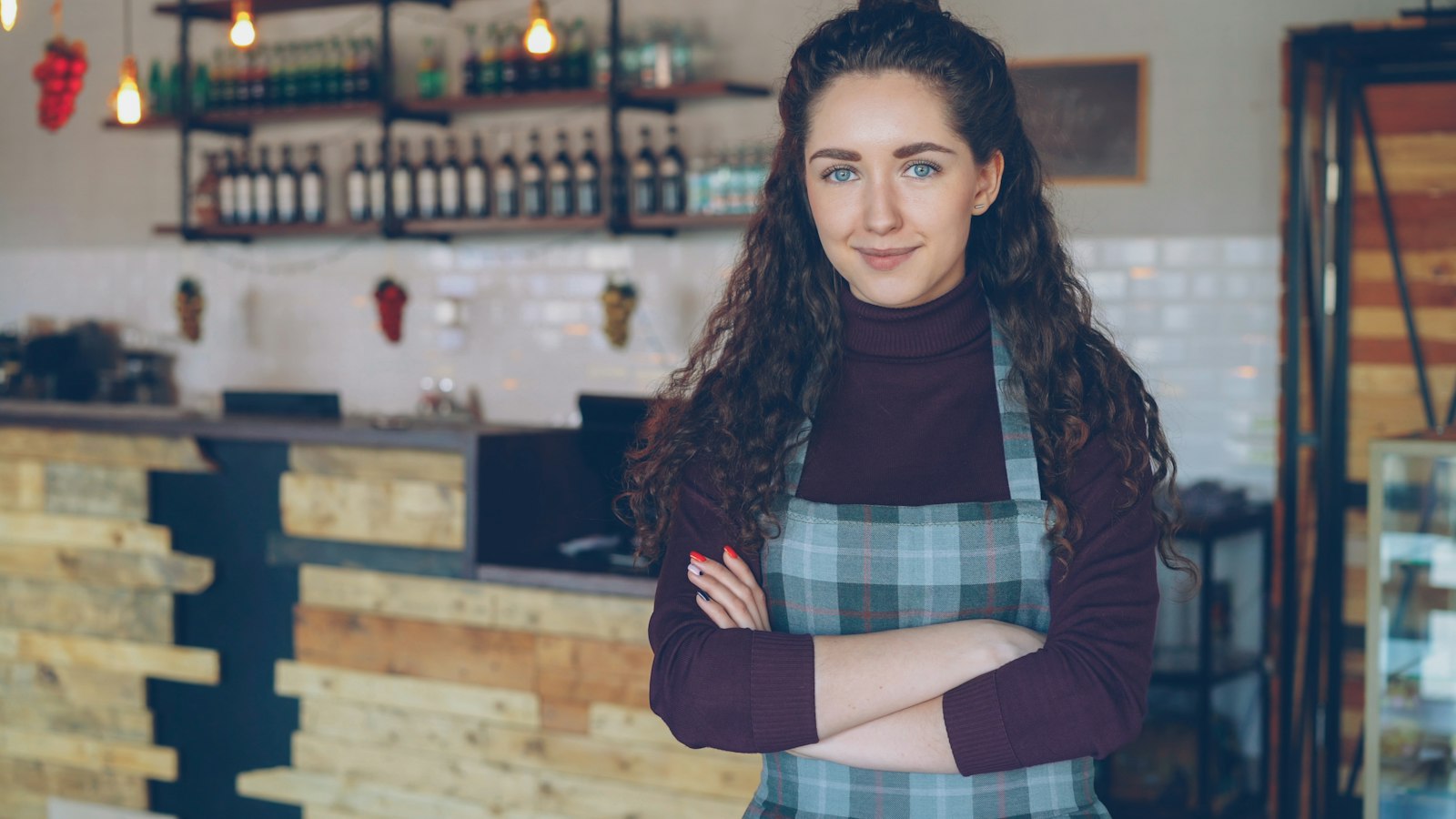A smiling café owner standing behind her counter